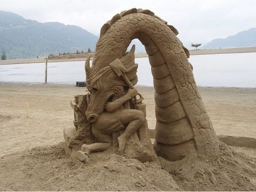 awesome pics - amazing sand sculpture of a dragon eating a man