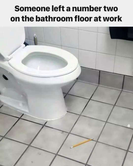 A pencil on the floor of a toilet room 